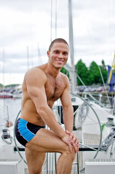 Svalová hezký námořník na své jachtě. — Stock fotografie