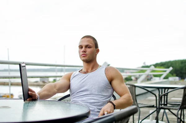 Guapo muscular masculina ordena comida en la cafetería de verano . —  Fotos de Stock