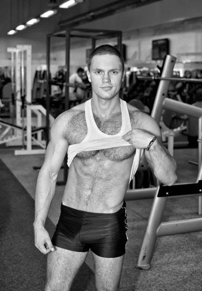 Bello bodybuilder mostrando il suo corpo in una palestra — Foto Stock