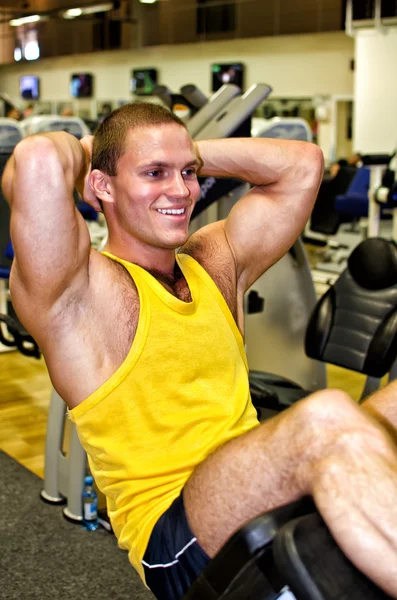 Portrait of handsome bodybuilder doing exercise in fitness club — Stock Photo, Image