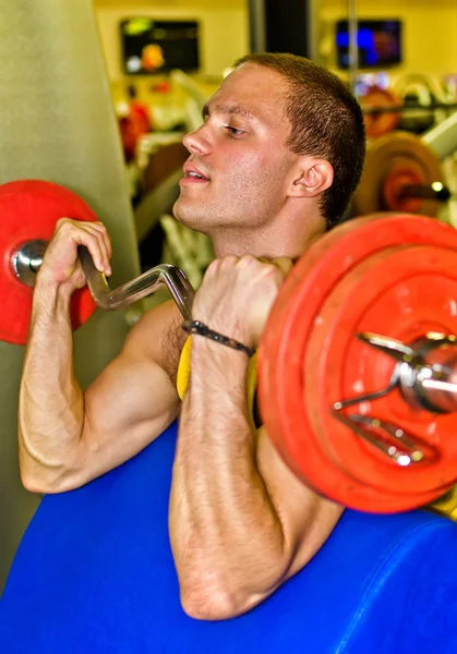 Portret van knappe bodybuilder doen oefening in fitnessclub — Stockfoto