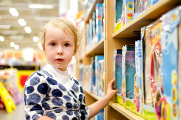 Dziewczynka jest zakupy w sklepie dla dzieci. — Zdjęcie stockowe