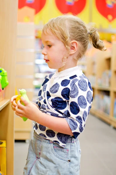 Menina está comprando na loja das crianças . — Fotografia de Stock