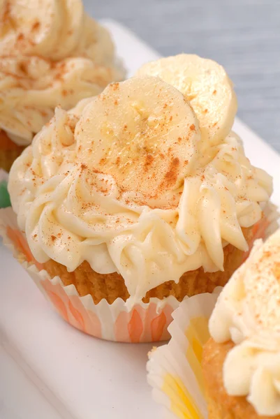Vanilla cupcake with cream cheese frosting and sliced bananas — Stock Photo, Image