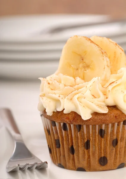 Vanille-Cupcake mit Frischkäse-Zuckerguss und geschnittenen Bananen — Stockfoto