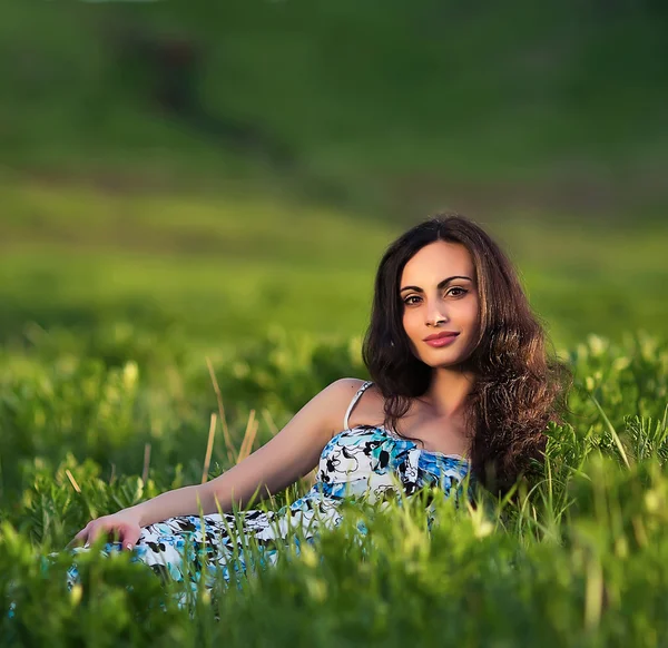 Piękny model siedzi w trawie — Zdjęcie stockowe