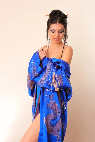 Flicka i blå asiatiska badrock med drakar — Stockfoto
