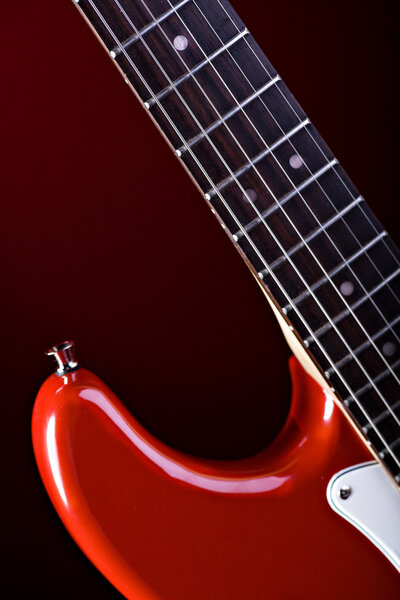 A close up shut of a red guitar