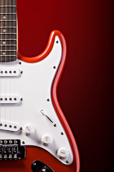 A close up shut of a red guitar