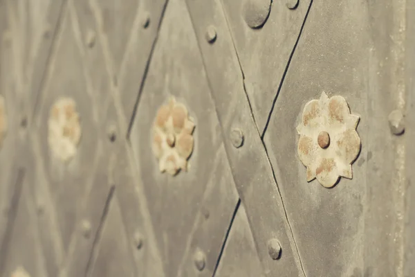 Gate with rivets and ancient style steel flowers — Stock Photo, Image