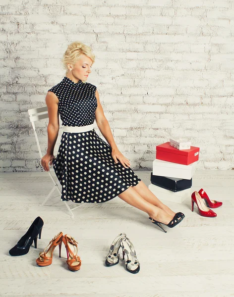 Shopaholic chica rubia en vestido sentado con zapatos y cajas —  Fotos de Stock