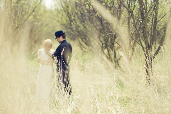 Appena sposati giovane coppia in giardino vestita retrò — Foto Stock