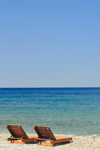 Два пляжных шезлонга, стоящих у моря — стоковое фото