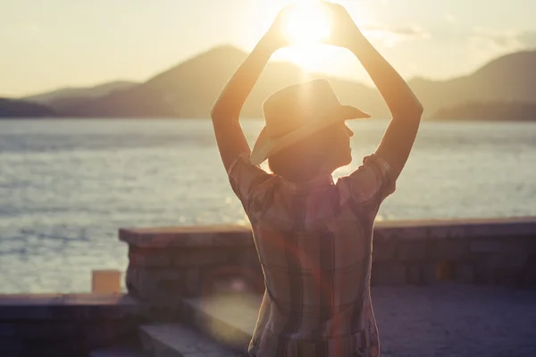 Západ slunce na pozadí zdvižené ruce žen — Stock fotografie