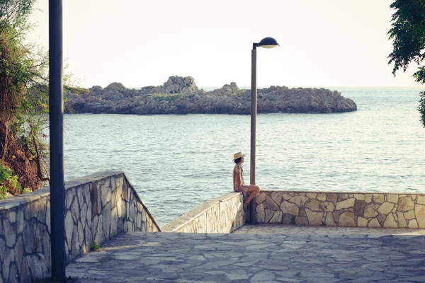 stock image Young girl sitting in front of the sea