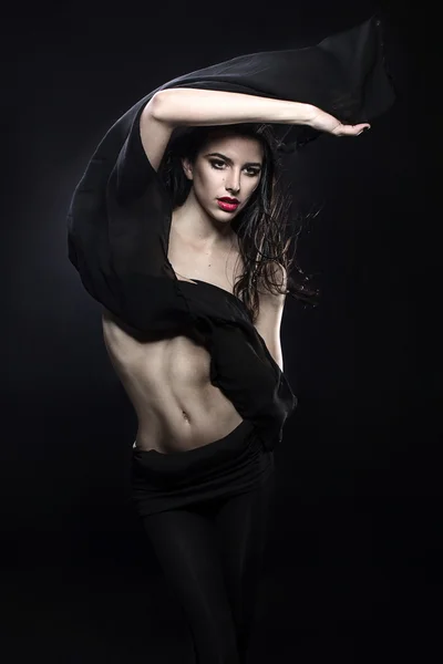 Jovem moda modelo grego segurando um tecido preto branco soprado pelo vento isolado estúdio tiro — Fotografia de Stock