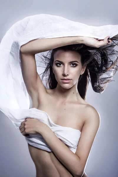 Ελληνικό μοντέλο μόδας της νεανικής μόδας, κρατώντας ένα λευκό μαύρο ύφασμα φυσητό από το στούντιο απομονωμένες άνεμος που πυροβόλησε — Φωτογραφία Αρχείου