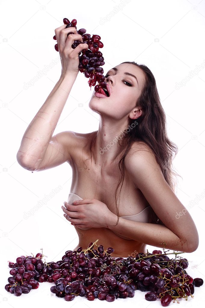 Beautiful young woman playing eating with grape