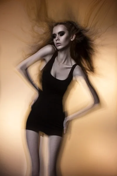 Студийный снимок красивой модели и сексуальной девушки с длинными волосами, дующими от ветра в белом сексуальном белье — стоковое фото