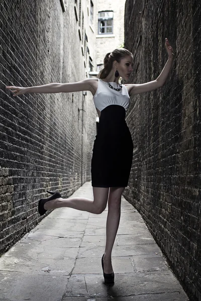 Alemão loira modelo de moda alta em um Londres Passing Alley posando vestindo vestido branco preto — Fotografia de Stock