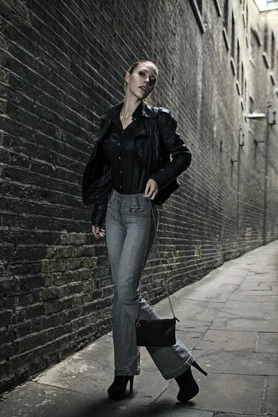 Duitse blonde hoog mode-model in een Londen passerende steegje poseren dragen van stedelijke outfits — Stockfoto
