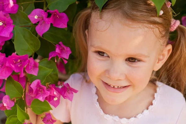 Porträt eines Mädchens auf einem Hintergrund aus Blumen — Stockfoto