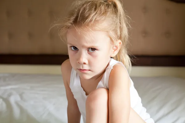 Üzgün çocuk yatağa oturur — Stok fotoğraf