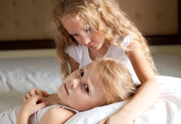 Две грустные девушки на кровати — стоковое фото