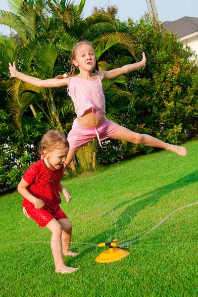 정원에서 놀고 있는 두 어린 소녀 — 스톡 사진