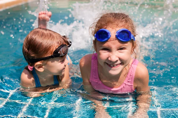 Two little girls playing in the pool — Stock Photo, Image