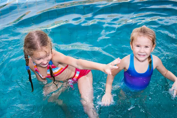 Dvě holčičky hrající si v bazénu — Stock fotografie