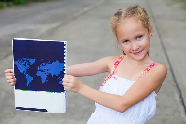 Barn, holder en bog med et kort - Stock-foto