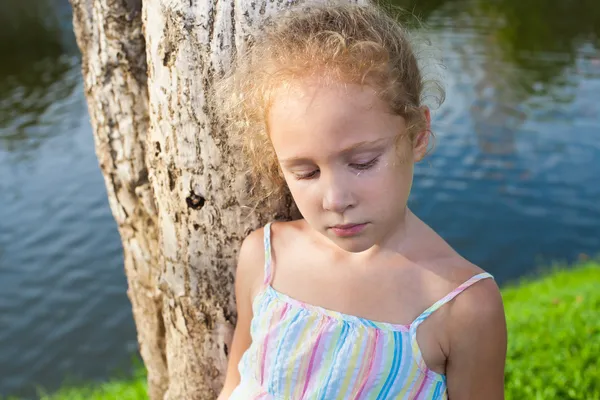 Triest meisje in de buurt van een boom — Stockfoto