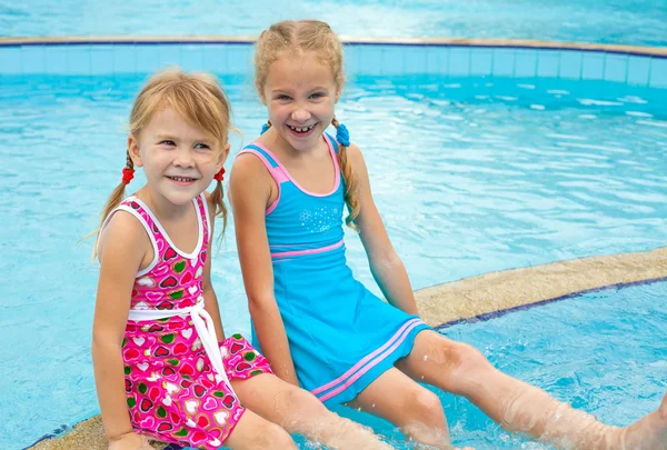 Две маленькие девочки играют в бассейне — стоковое фото