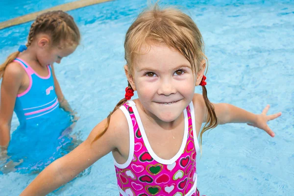 Twee kleine meisjes spelen in het zwembad — Stockfoto