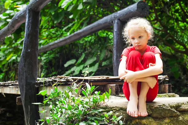 Triest meisje op een houten brug — Stockfoto