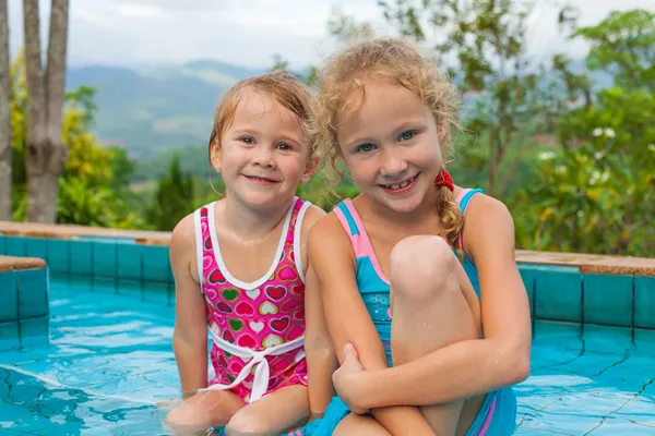 Duas meninas brincando na piscina — Fotografia de Stock