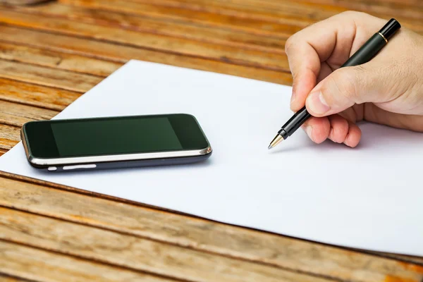 Livro branco em branco com caneta e um telefone móvel — Fotografia de Stock