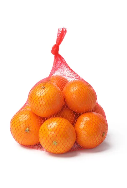 Pomarańcze w worku siatki z tworzywa sztucznego — Zdjęcie stockowe