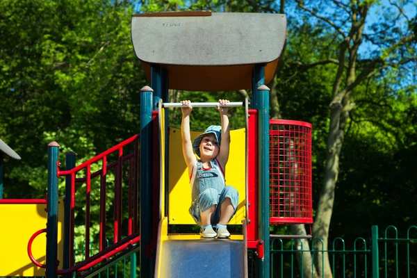 Child hanging on a slide — Stock Photo, Image