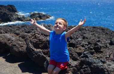 Child with his hands up in the sky clipart