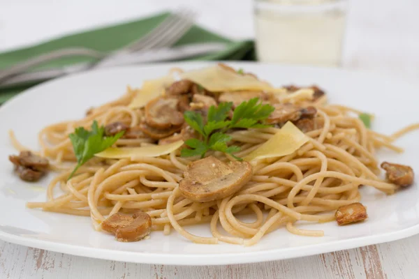Спагетти с грибами и сыром на тарелке — стоковое фото