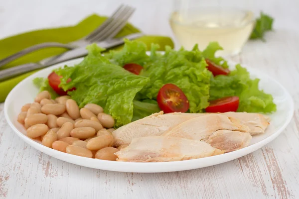 Vařené kuře s fazolkami a salát na talíři — Stock fotografie