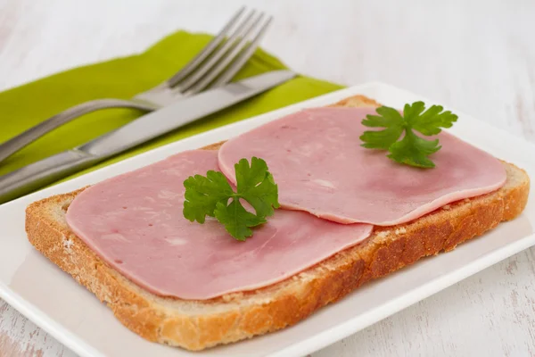 Bread with ham and parsley on the plate — Stock Photo, Image