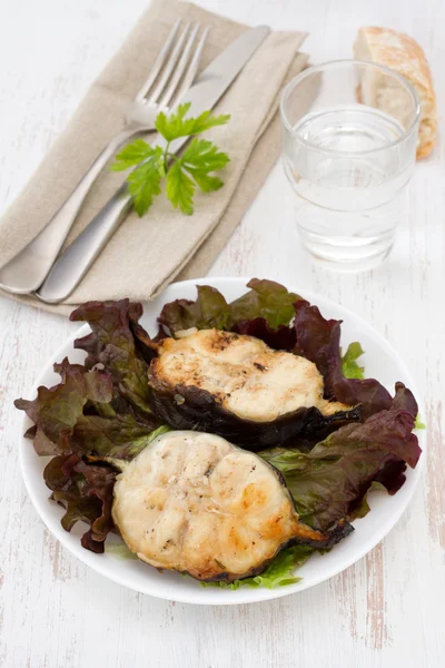 Жареная рыба с салатом на белой тарелке — стоковое фото