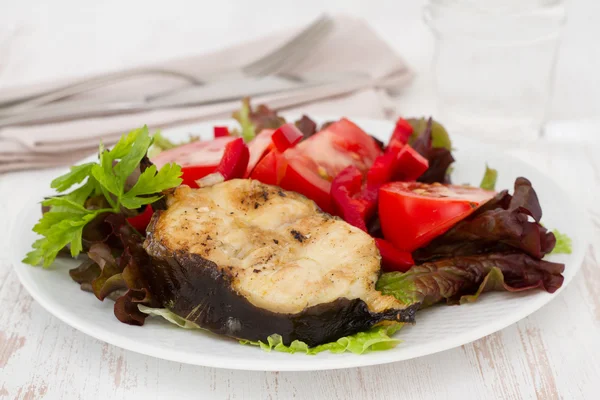 Peixe grelhado com salada no prato branco — Fotografia de Stock