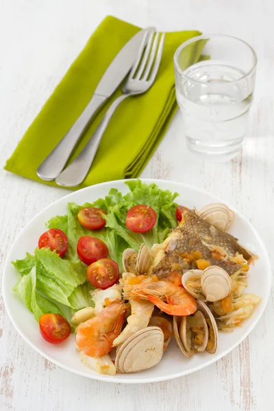 Fish stew with salad on the white plate