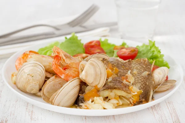 Тушеная рыба с салатом на белой тарелке — стоковое фото