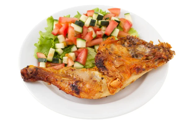 Жареная курица с овощным салатом на тарелке — стоковое фото