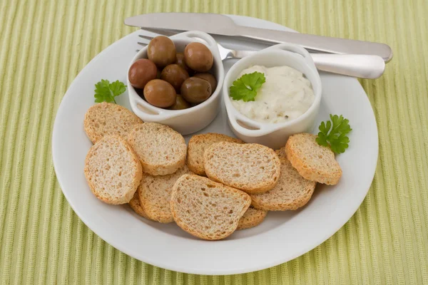 Toasts with olives and sauce — Stock Photo, Image